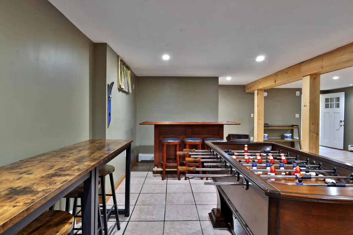 An inviting indoor scene featuring a foosball table, bar counter with stools, and playful décor—suggesting lively game nights and friendly tournaments for all ages.