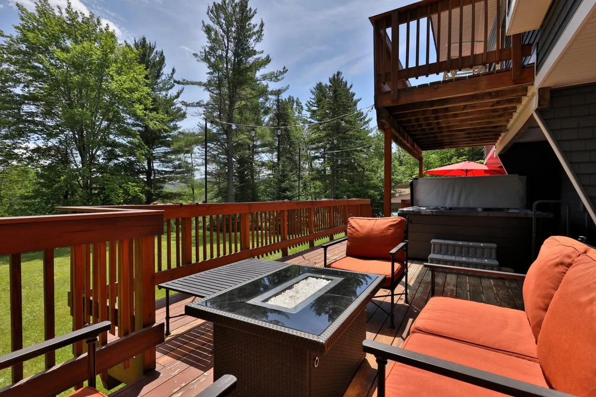 The photo features an outdoor seating area with a fire pit and greenery all around. The setup is ideal for relaxing with friends and family, enjoying casual outdoor meals, or stargazing together in the evenings.